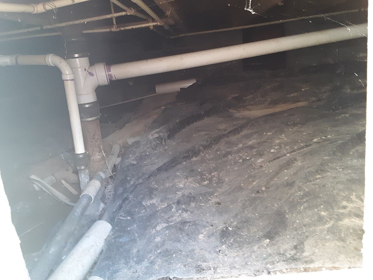 Dirt-floor crawl space beneath a house